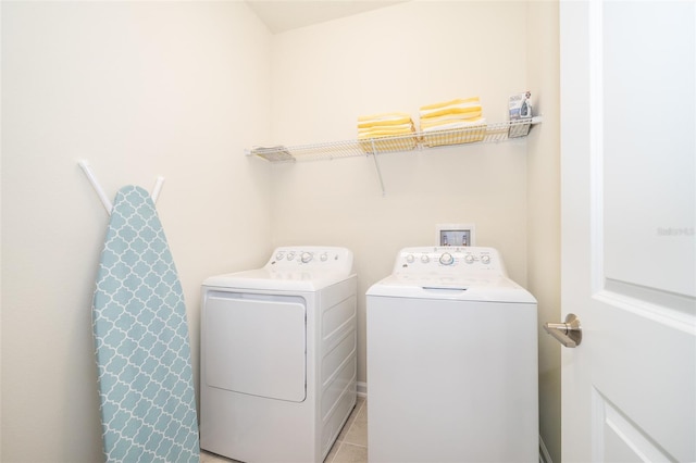 laundry area featuring light tile floors, washer hookup, and washing machine and clothes dryer