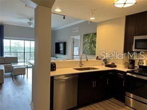 kitchen featuring ceiling fan, ornamental molding, stainless steel appliances, and sink