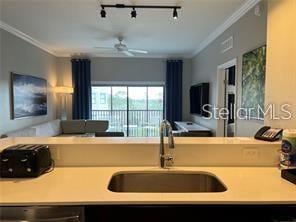 kitchen with crown molding, ceiling fan, dishwashing machine, and sink