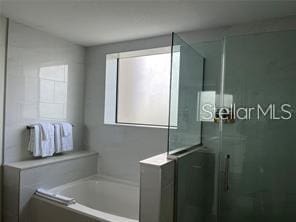 bathroom with separate shower and tub