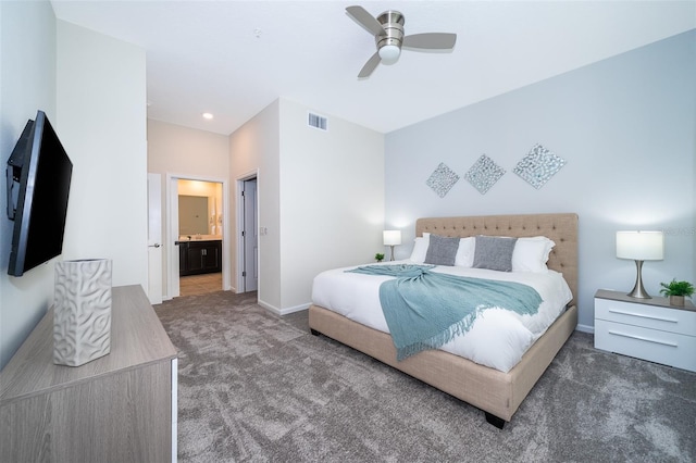 bedroom with dark carpet, ceiling fan, and ensuite bathroom