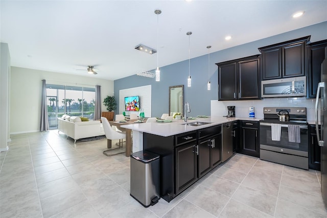 kitchen featuring pendant lighting, stainless steel appliances, light tile floors, ceiling fan, and sink