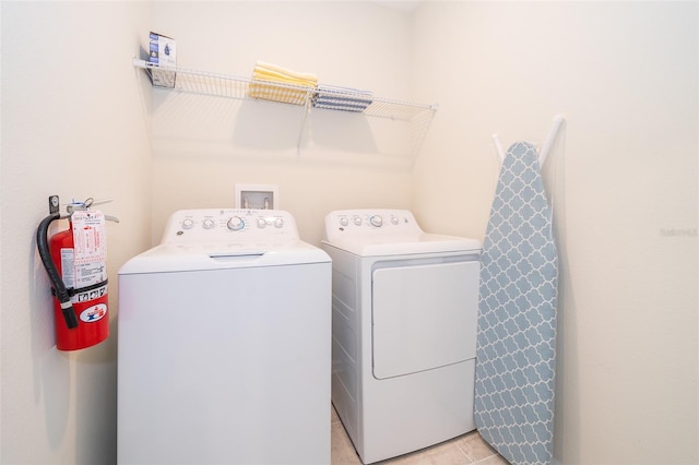 washroom featuring light tile floors, separate washer and dryer, and hookup for a washing machine