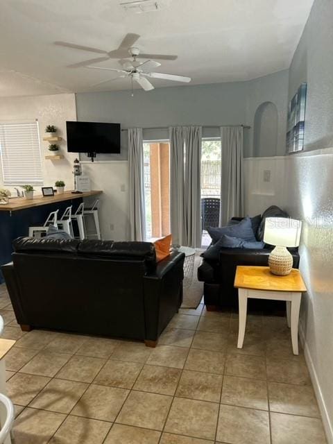 tiled living room featuring ceiling fan