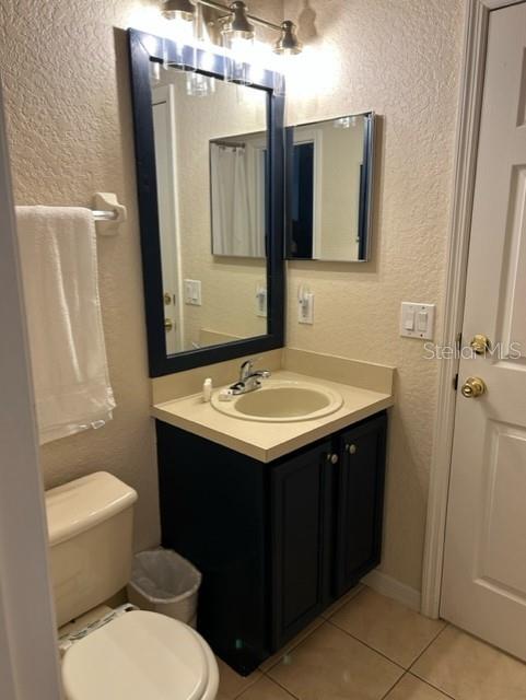 bathroom featuring tile patterned flooring, vanity, and toilet