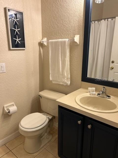 bathroom with tile patterned floors, vanity, and toilet