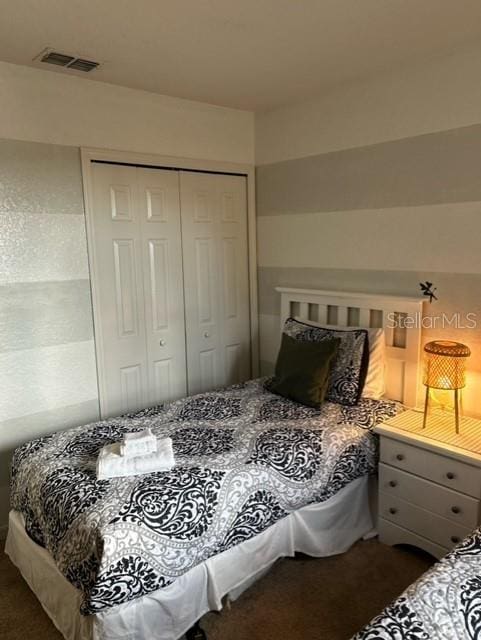 bedroom featuring dark colored carpet and a closet