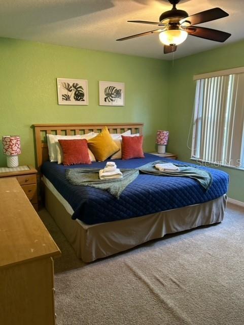 carpeted bedroom with ceiling fan