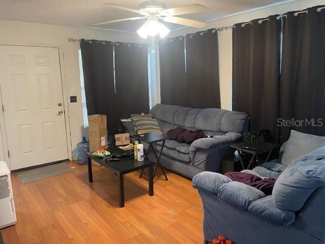 living room with light hardwood / wood-style flooring and ceiling fan