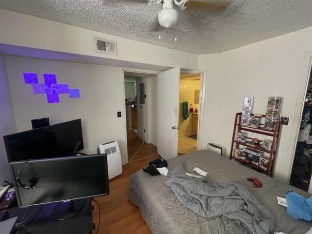 bedroom featuring a textured ceiling, hardwood / wood-style flooring, and ceiling fan