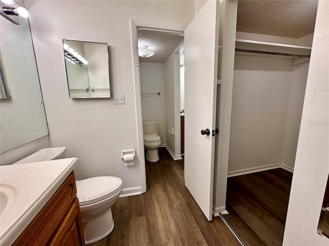 bathroom with hardwood / wood-style flooring, a textured ceiling, and toilet