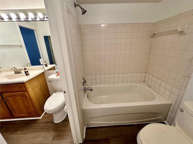 full bathroom featuring toilet, tiled shower / bath combo, and wood-type flooring