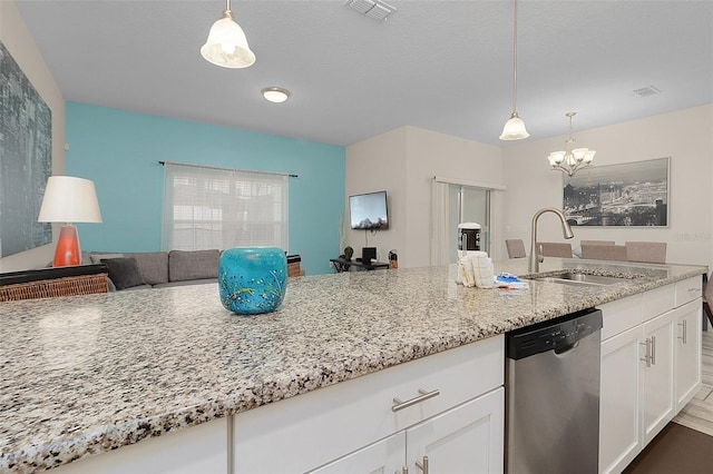 kitchen with light stone countertops, hanging light fixtures, dishwasher, and sink