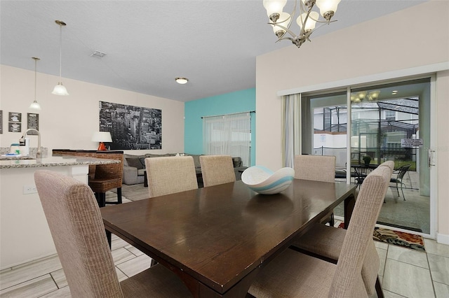 dining space featuring light tile floors, sink, and an inviting chandelier