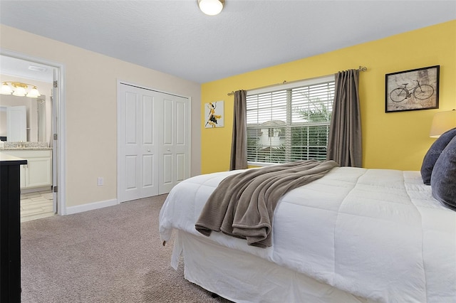 carpeted bedroom featuring a closet and ensuite bathroom