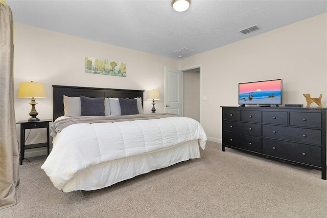 bedroom featuring a textured ceiling and light colored carpet