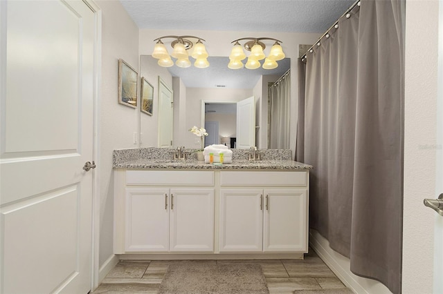 bathroom with a chandelier and double vanity