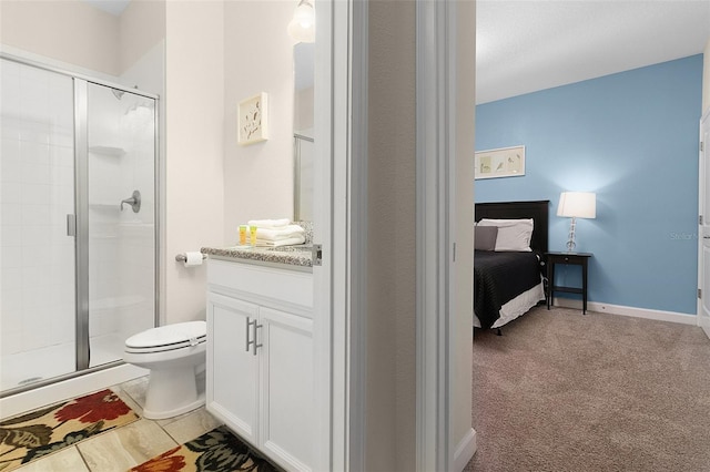 bathroom featuring toilet, vanity, a shower with door, and tile flooring