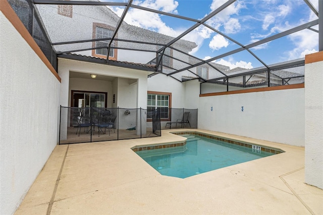 view of swimming pool featuring a patio area and glass enclosure