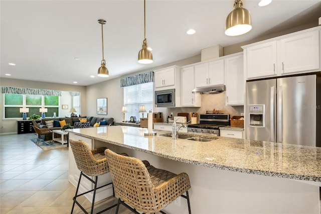 kitchen featuring backsplash, white cabinetry, appliances with stainless steel finishes, and pendant lighting