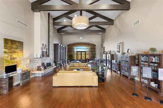 living room featuring high vaulted ceiling, beam ceiling, dark hardwood / wood-style flooring, and a fireplace