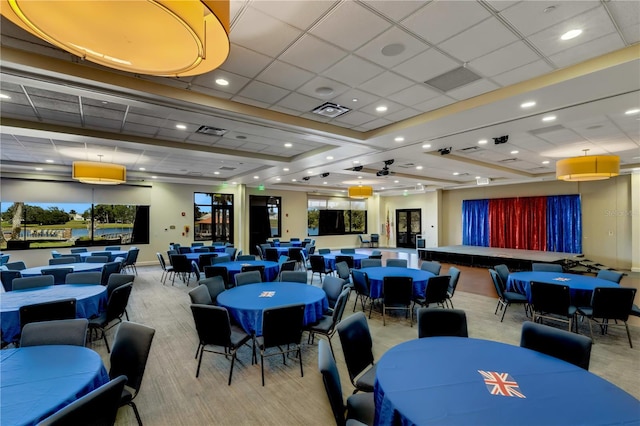 carpeted dining area with ceiling fan and a drop ceiling