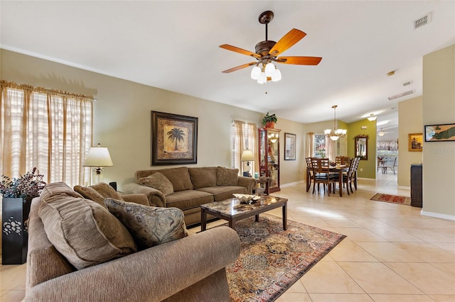 tiled living room with ceiling fan with notable chandelier