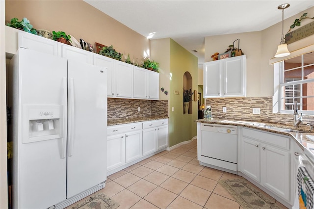 kitchen with white appliances, light tile floors, white cabinets, tasteful backsplash, and decorative light fixtures