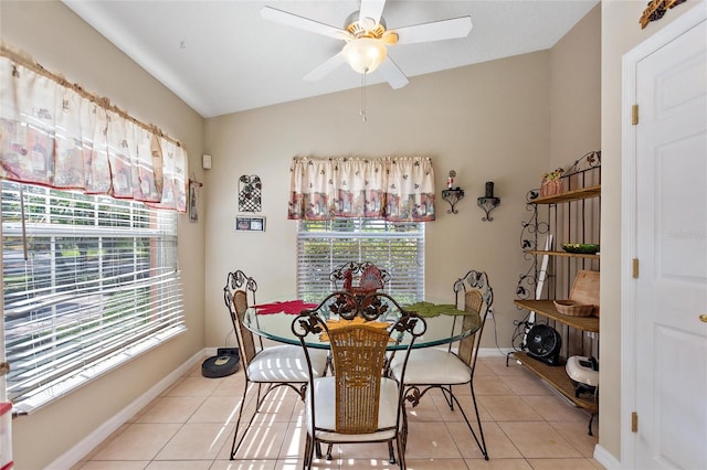 dining space with light tile floors, lofted ceiling, and ceiling fan