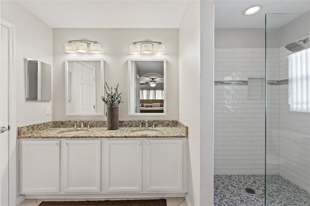 bathroom featuring a shower with door, double vanity, and tile flooring