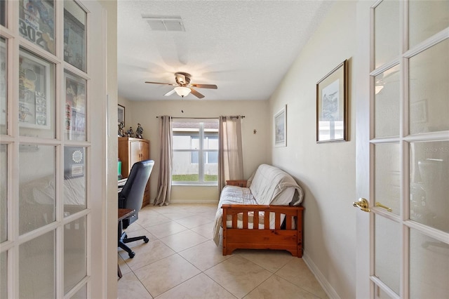 office area with light tile floors, a textured ceiling, and ceiling fan