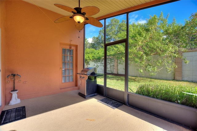 unfurnished sunroom with wooden ceiling, ceiling fan, and a healthy amount of sunlight