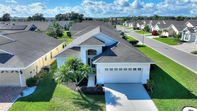 view of front facade featuring central AC unit, solar panels, and a front lawn