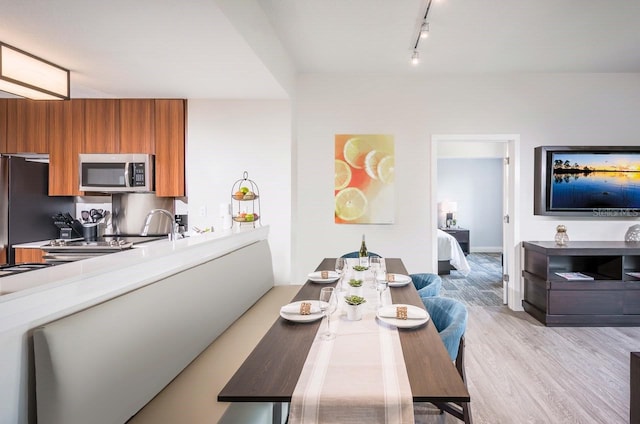 dining room with rail lighting and light hardwood / wood-style flooring