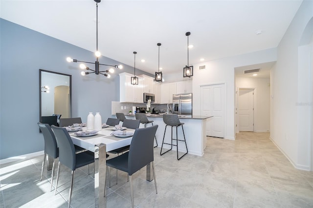 tiled dining room featuring an inviting chandelier