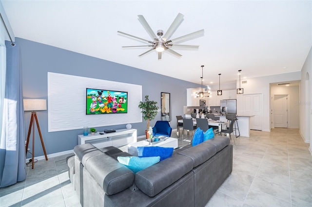 tiled living room featuring ceiling fan with notable chandelier