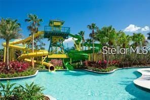 pool with a water slide and a water play area