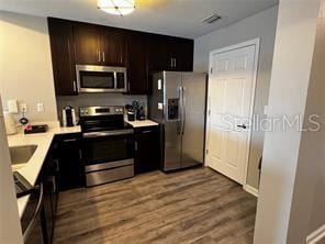 kitchen with stainless steel appliances, light countertops, and wood finished floors