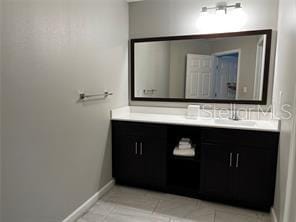 bathroom featuring tile patterned flooring, vanity, and baseboards