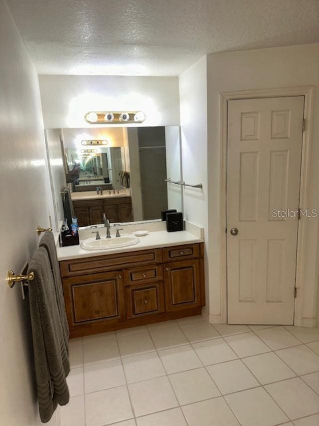 bathroom featuring tile patterned flooring, vanity, and a textured ceiling