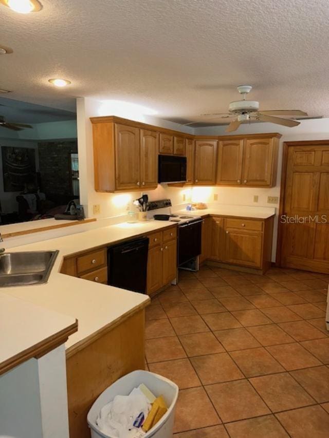 kitchen with kitchen peninsula, a textured ceiling, sink, and black appliances