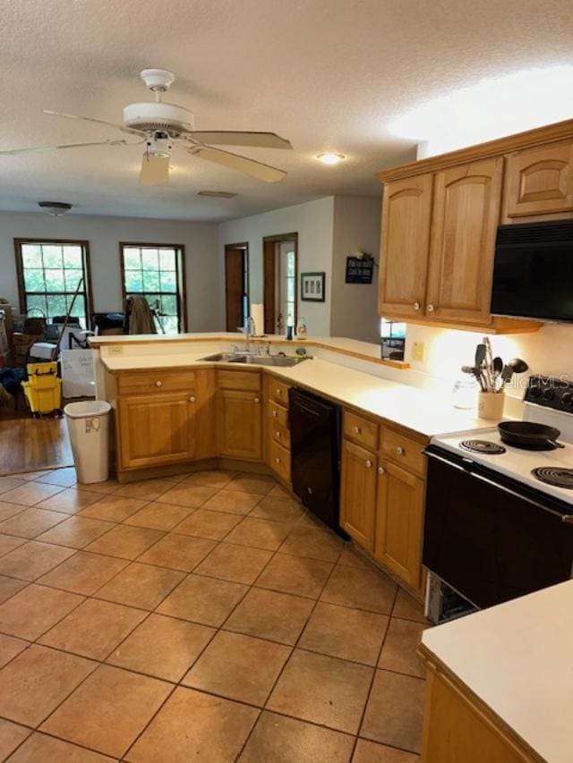 kitchen featuring black appliances, sink, light tile patterned floors, a textured ceiling, and kitchen peninsula