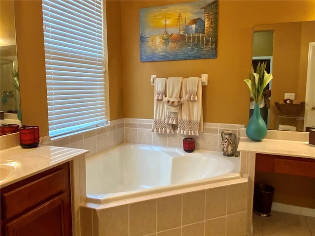 bathroom with tile patterned floors, tiled tub, and vanity