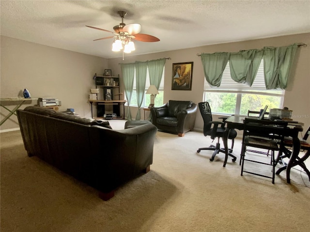 carpeted living room with a textured ceiling and ceiling fan