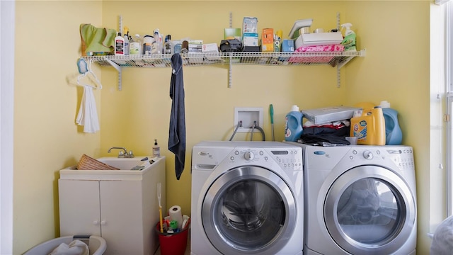 clothes washing area with cabinets and washing machine and clothes dryer