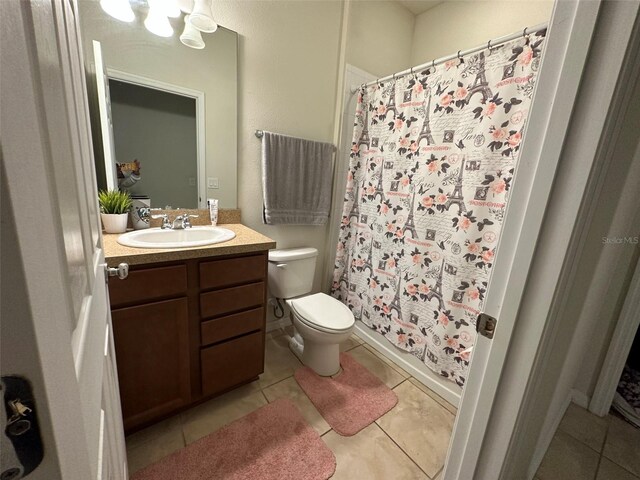 bathroom with tile patterned flooring, vanity, curtained shower, and toilet