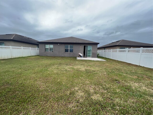 back of house with a yard and a patio area