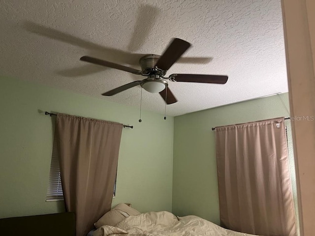 bedroom featuring ceiling fan and a textured ceiling