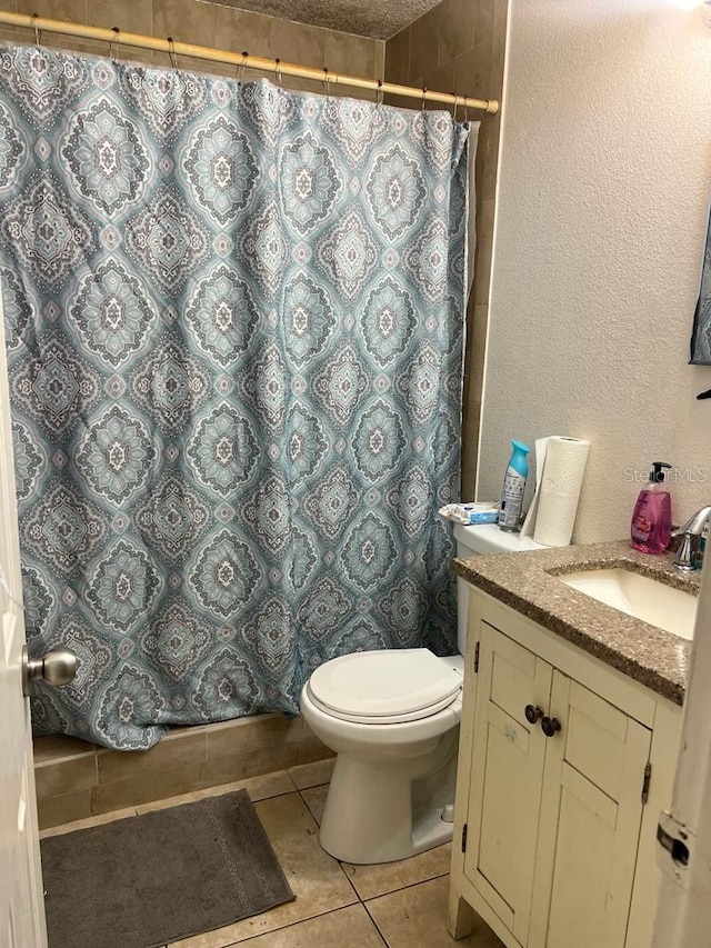 bathroom with tile patterned floors, a shower with curtain, vanity, and toilet