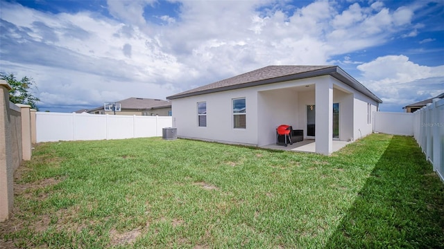 rear view of house featuring a lawn, a patio, and central AC unit